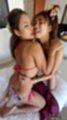 Kneeling together on bed girls kissing wearing bikinis